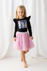 Malá dívka v černé blůzce s potiskem jednorožce a růžové tylové sukni. Stylový a pohodlný outfit pro každou malou princeznu.