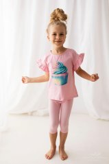 Usměvavá holčička v růžovém tričku s barevným cupcakem a volánkovými rukávy – pohodlný a hravý outfit ideální pro každý den.