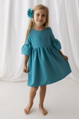 Tyrkysové dívčí šaty v boho stylu zaujmou jednoduchým, ale elegantním střihem. Mají volné tříčtvrteční rukávy s výraznými volány
