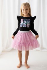Malá dívka v černé blůzce s potiskem jednorožce a růžové tylové sukni. Stylový a pohodlný outfit pro každou malou princeznu.